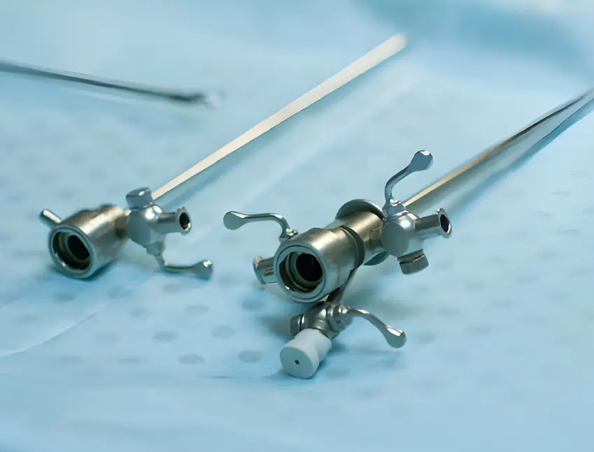 Two laparoscopic tools on a sterile blue surface, representing medical instruments that benefit from ARKA's coatings to enhance abrasion and corrosion resistance.