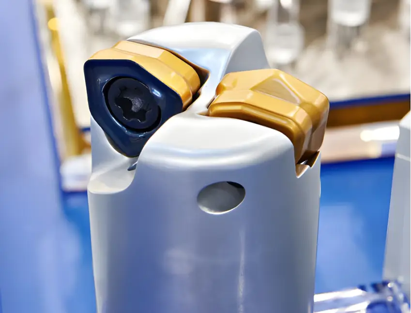 A close-up of a high-precision tool head with gold-colored cutting inserts, showcasing the classic appearance of Titanium Nitride (TiN) PVD coating known for its high hardness and low friction.