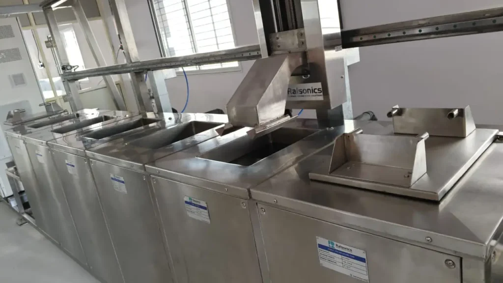 A photograph of the multi-stage industrial ultrasonic cleaning machine used for precision surface preparation of PVD coating substrates.